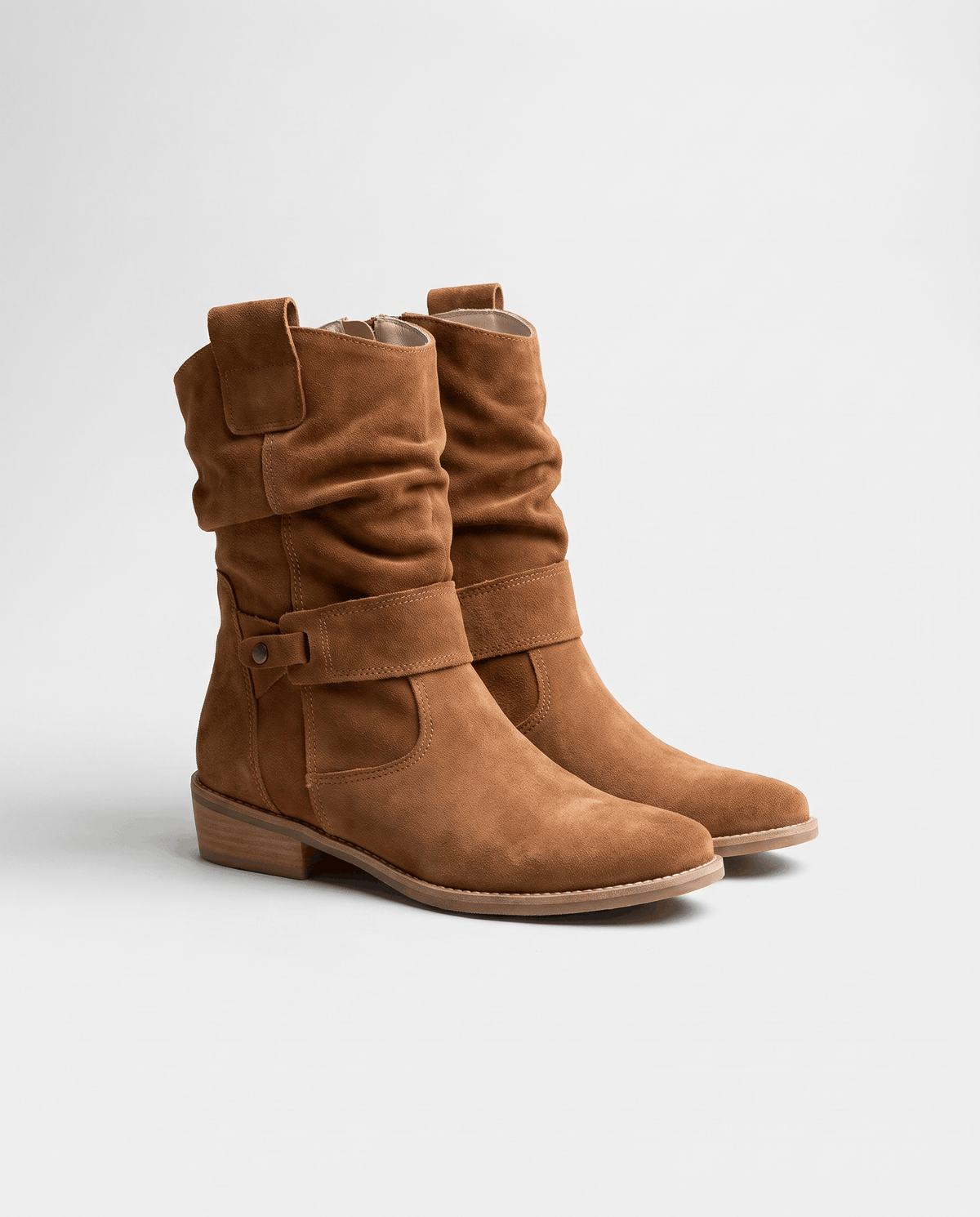 Tan suede slouch boots angled to show the side zip