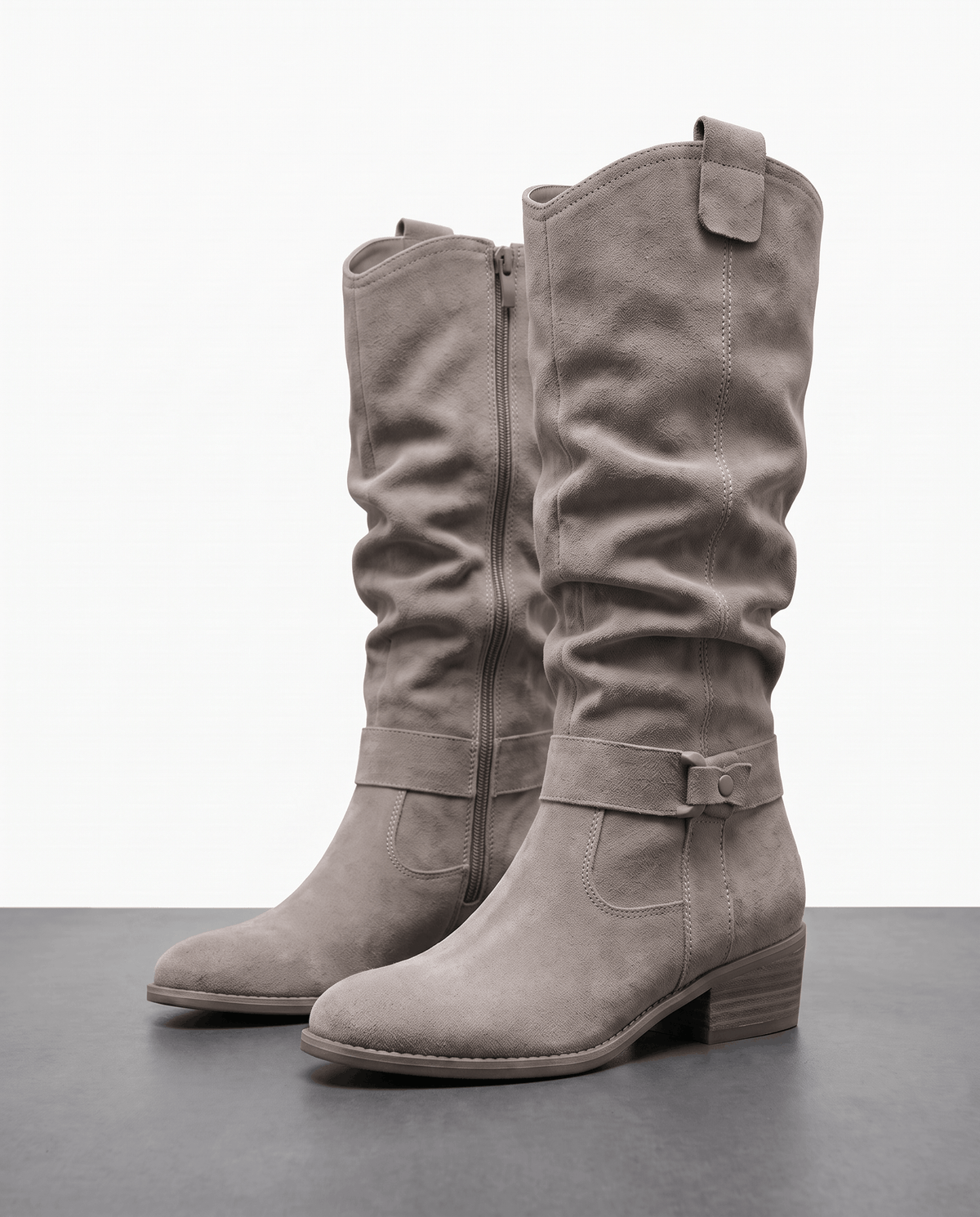 Gray vegan suede knee-high slouch boots with a side zip and ankle strap, displayed against a white studio background.