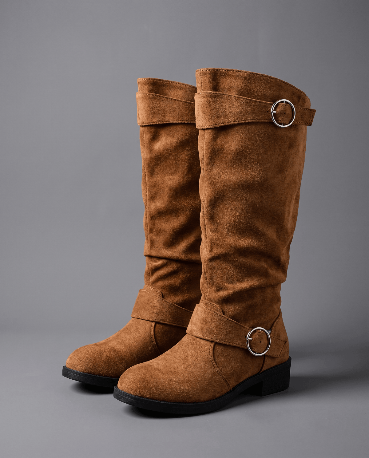 Dark brown vegan suede knee-high boots with a slouched shaft, round toe, low heel, and twin silver ring strap accents.