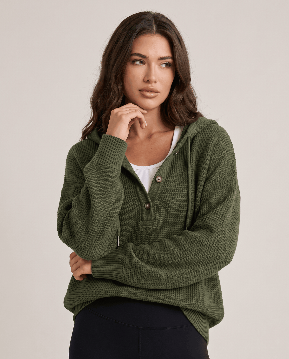 Army green knit hoodie with buttoned neckline layered over a white top, front view