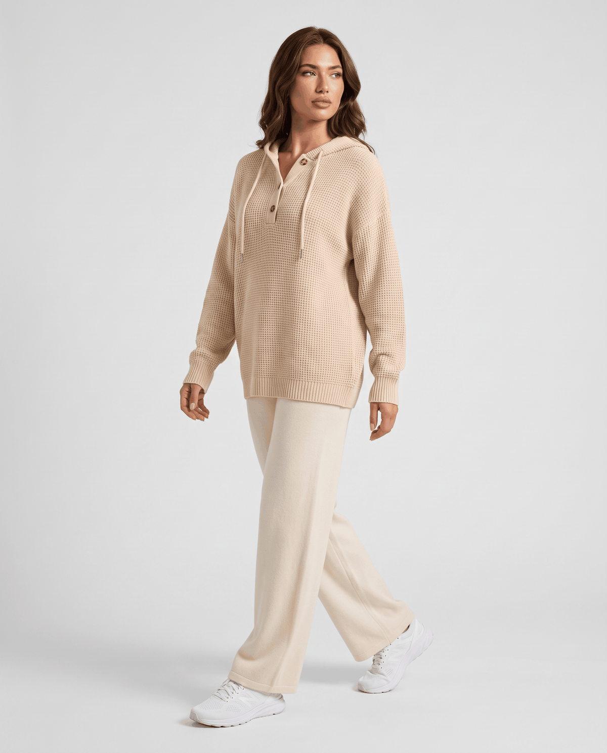 Full-length walking look pairing the beige hoodie with cream wide-leg pants and white sneakers