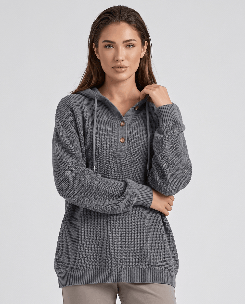 Gray waffle knit hoodie worn with a hand raised to the drawstring, front view