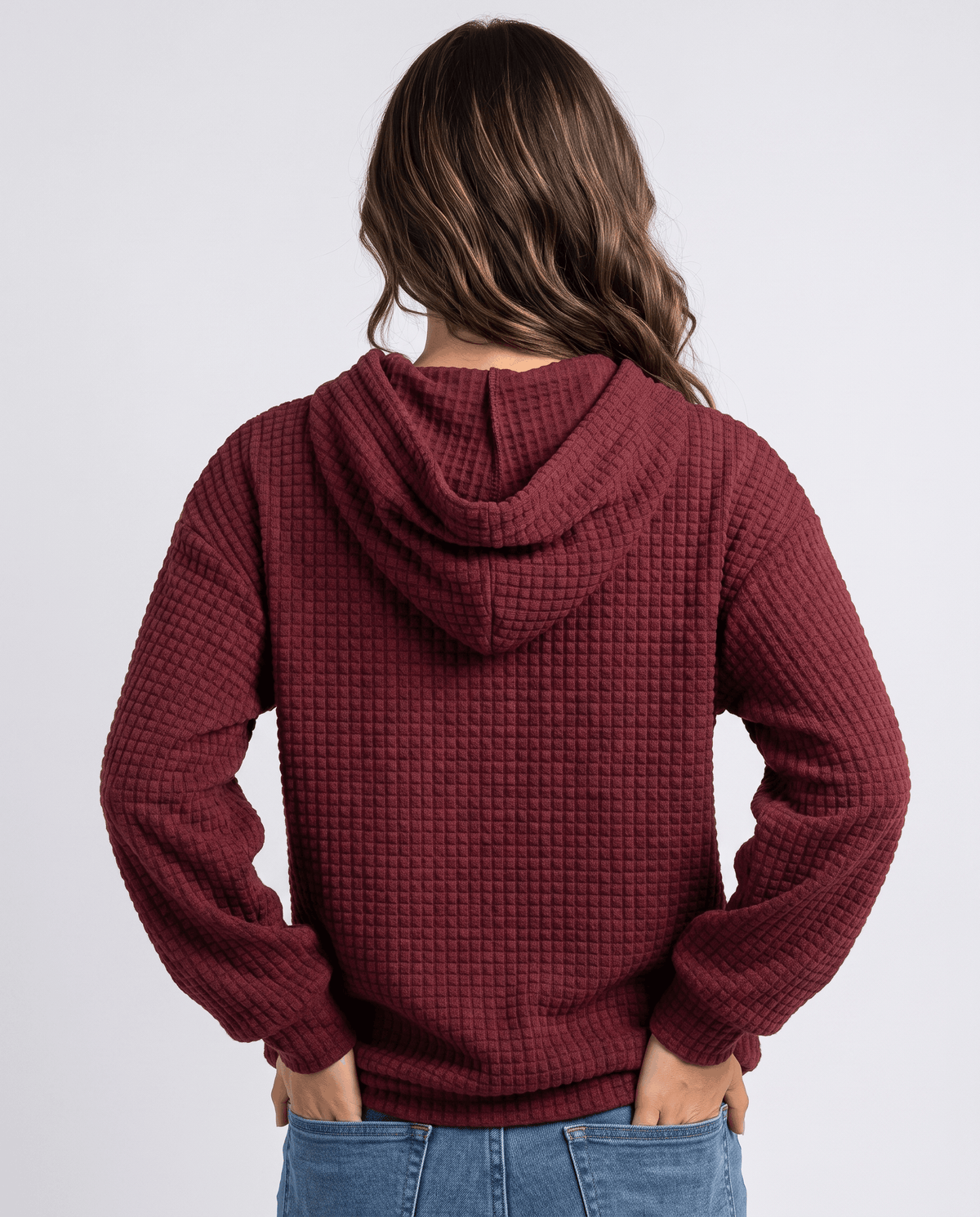 Burgundy hoodie from behind with the hood up and relaxed waffle knit sleeves