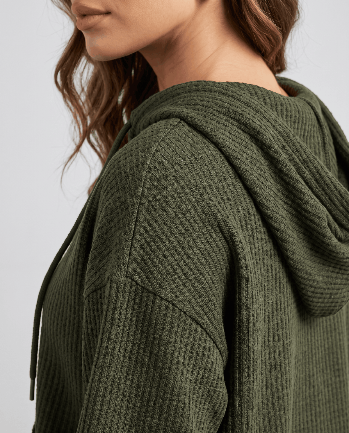 Close-up of dark green hood and drawstring showing the waffle knit pattern