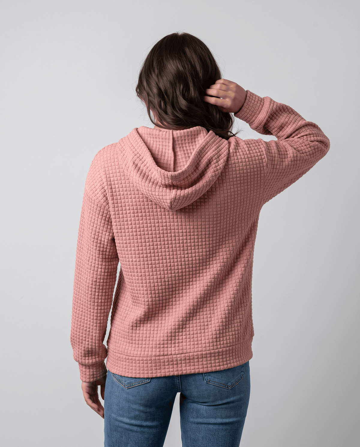 Back of dusty pink pullover hoodie with the hood down and relaxed waffle knit body