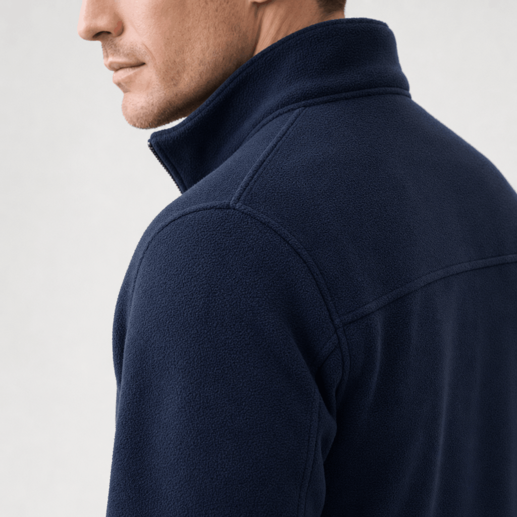 Close-up back and side view of a navy blue zip-up jacket, highlighting the stand collar and shoulder.