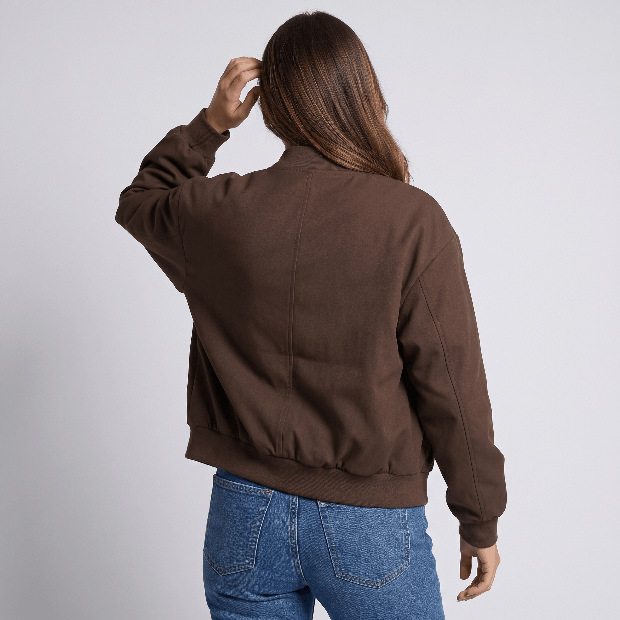 Female model wearing the dark brown bomber jacket, showing the back and ribbed waistband.