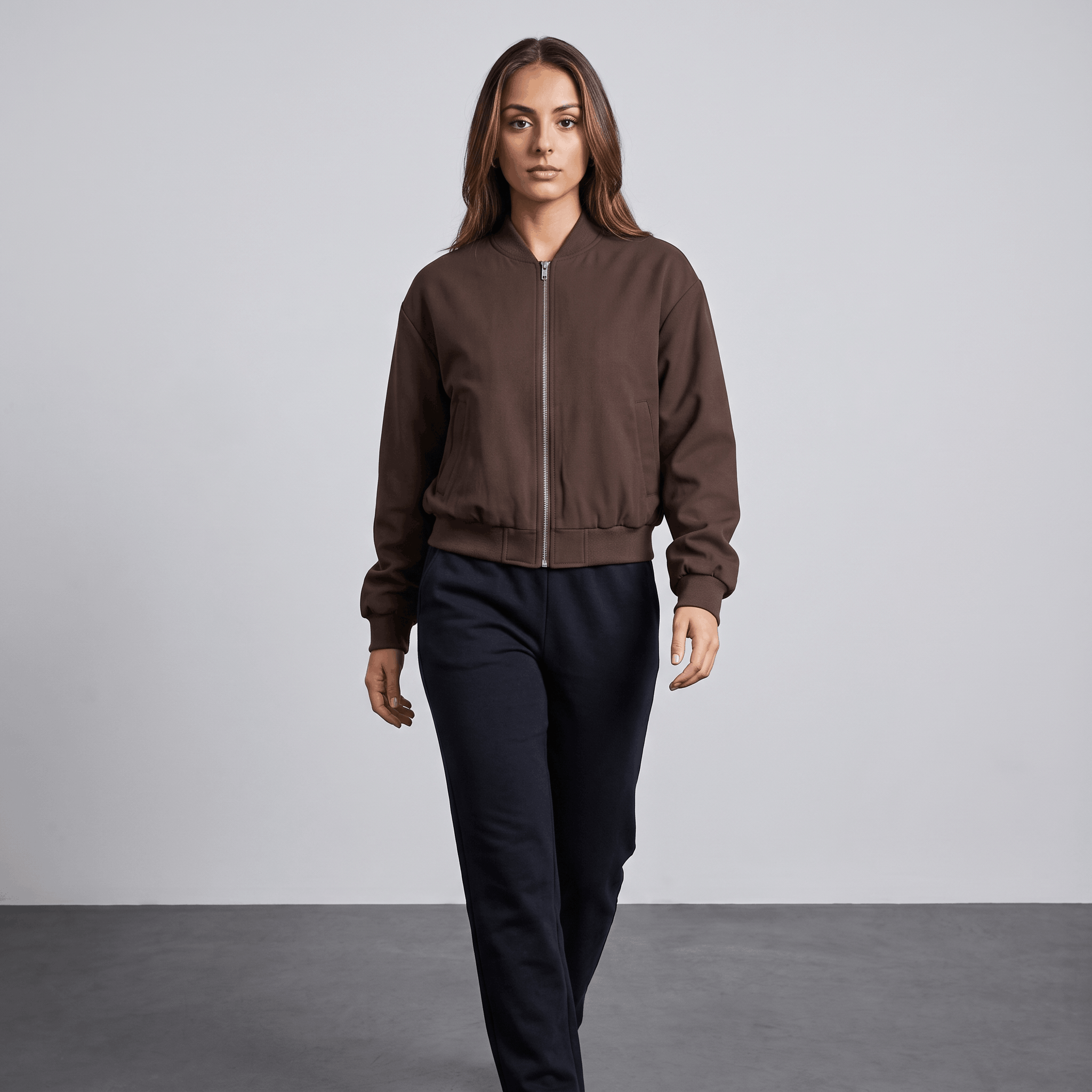 Female model wearing the dark brown bomber jacket with dark trousers.
