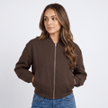 Female model wearing a dark brown zip-up bomber jacket with a stand collar, ribbed cuffs and hem, and side pockets, paired with blue jeans.