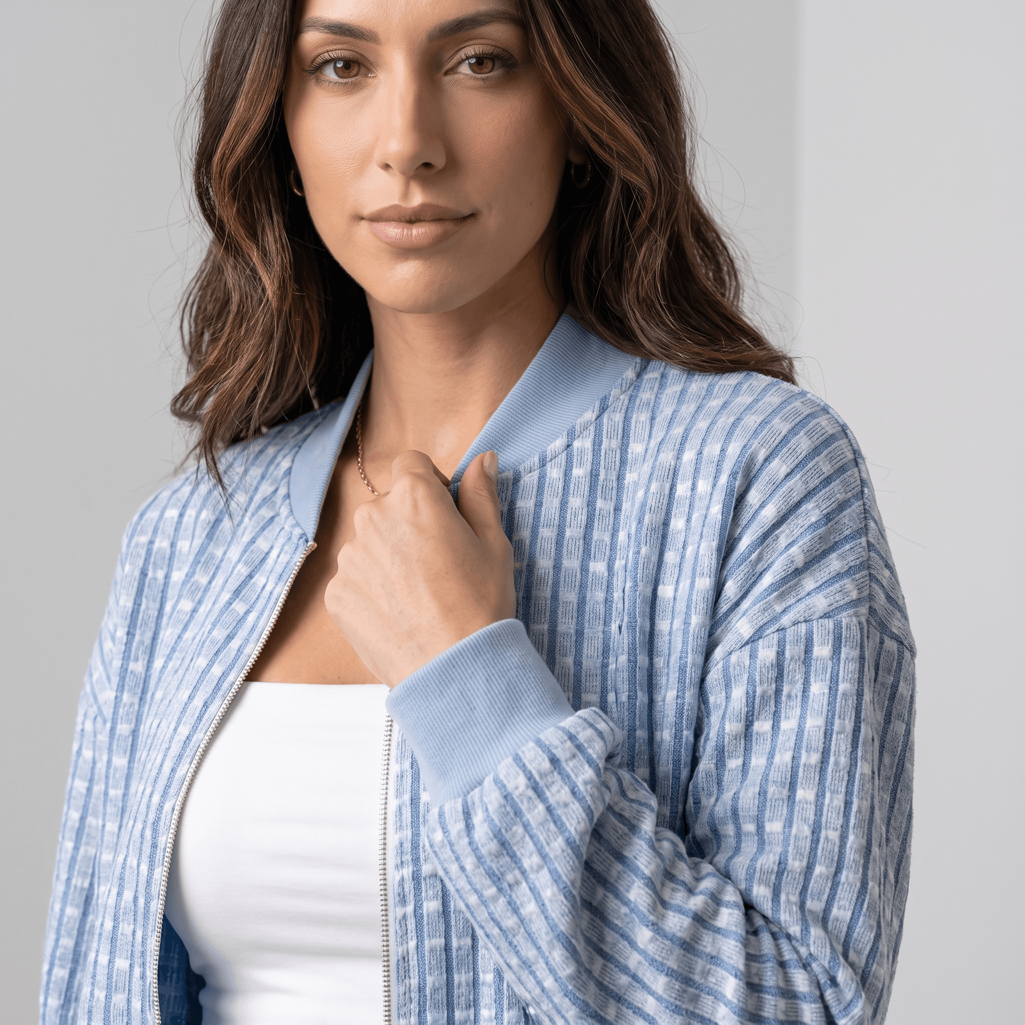 Female model wearing the light blue textured jacket, highlighting the stand collar, zipper, and woven texture.