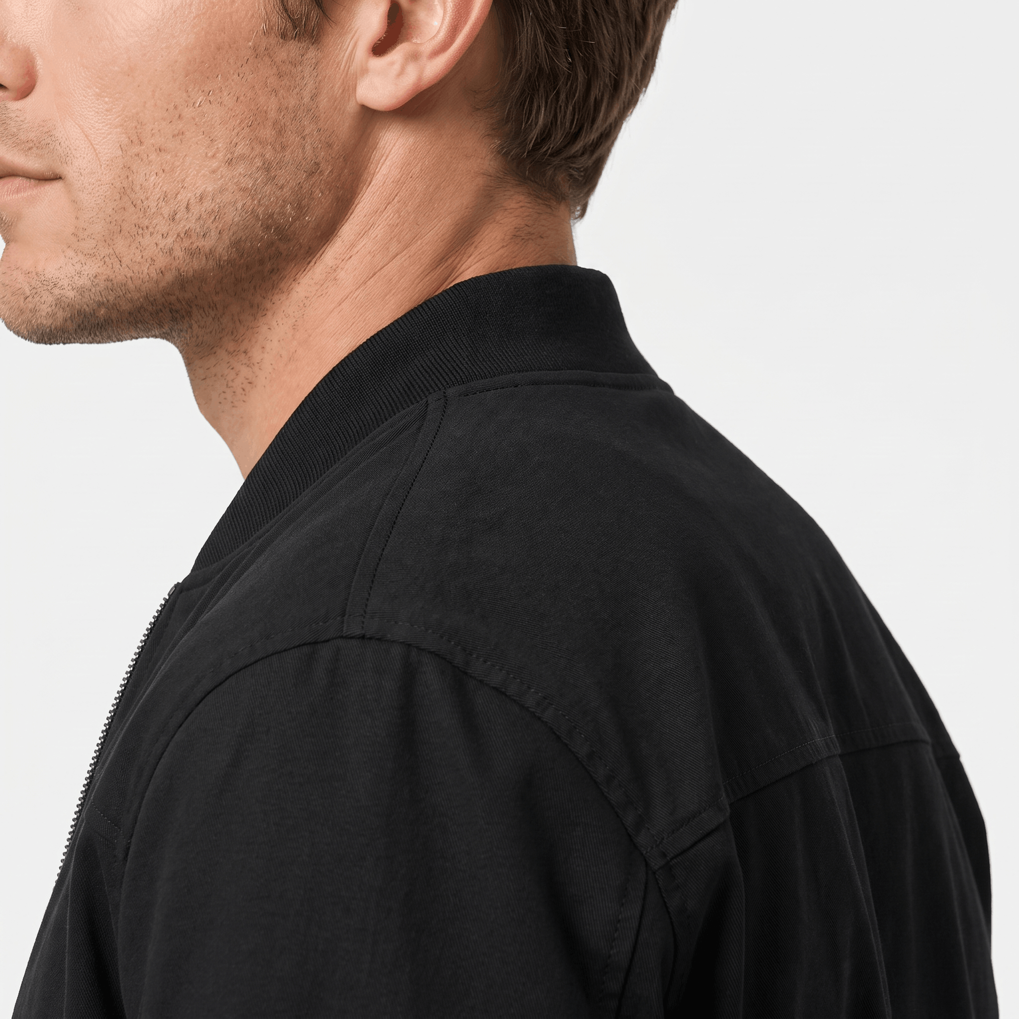 Close-up back and side view of the black bomber jacket, showing the collar and shoulder seams.