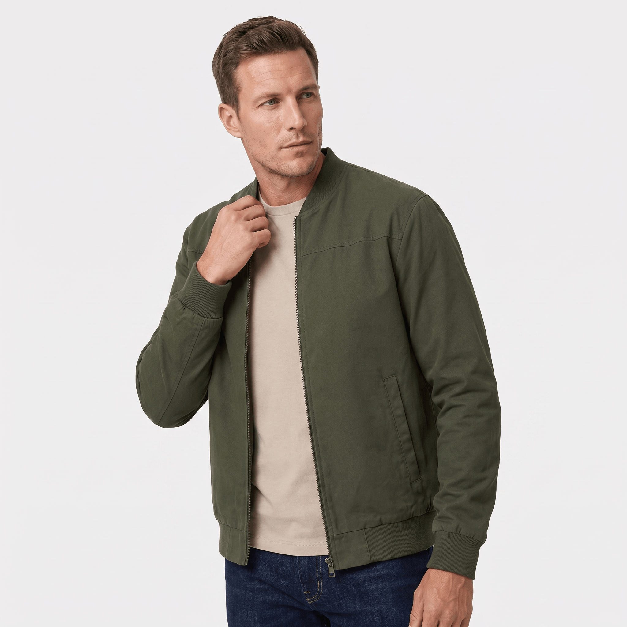 Male model wearing an olive green bomber jacket over a beige shirt.