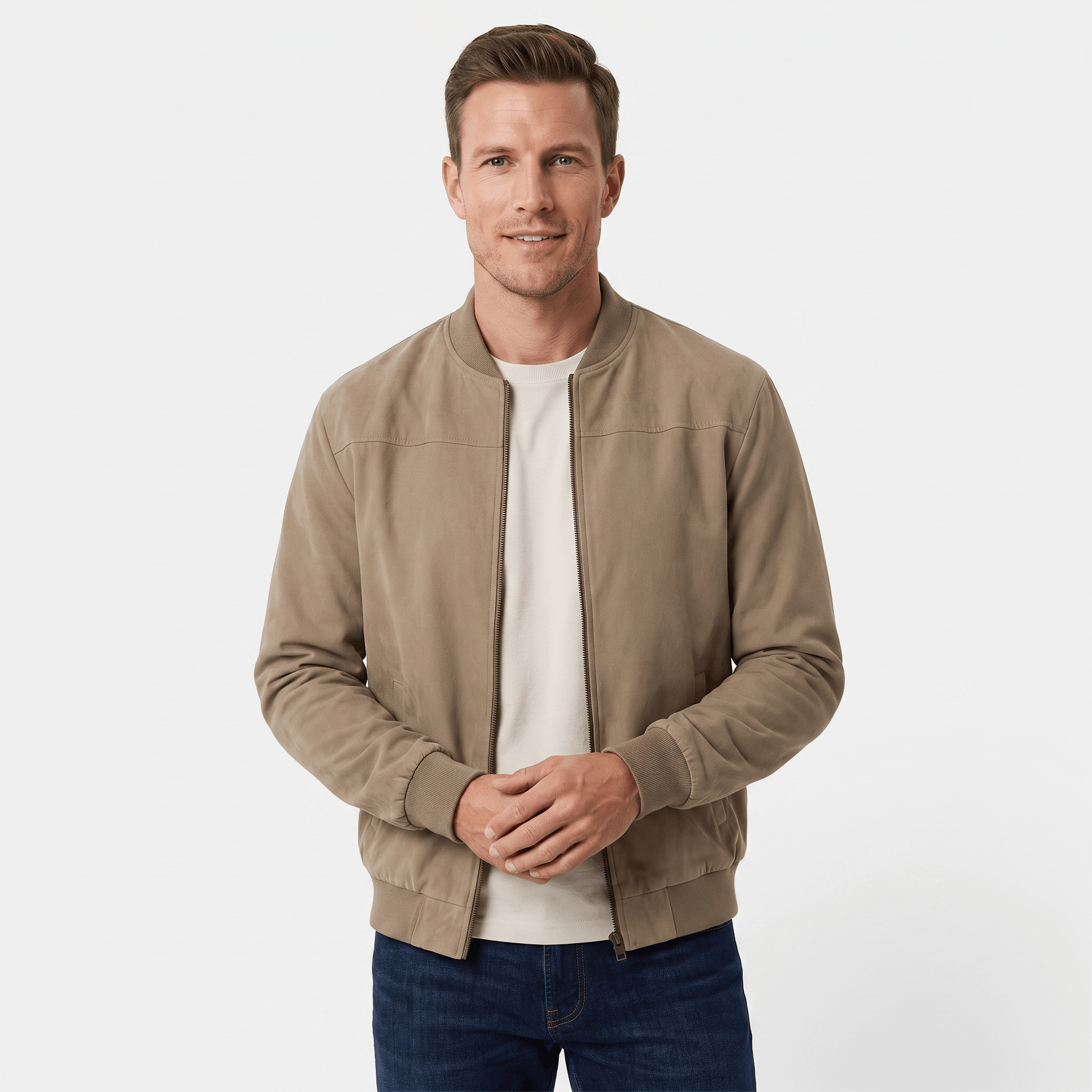 Male model wearing a beige bomber jacket over a light-colored shirt with blue jeans.