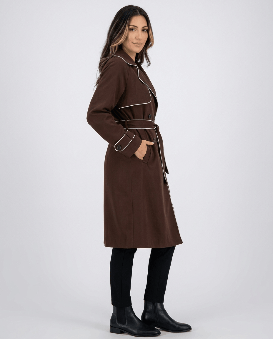 Brown belted trench coat for women worn by a female model, side view with defined waist and tie belt