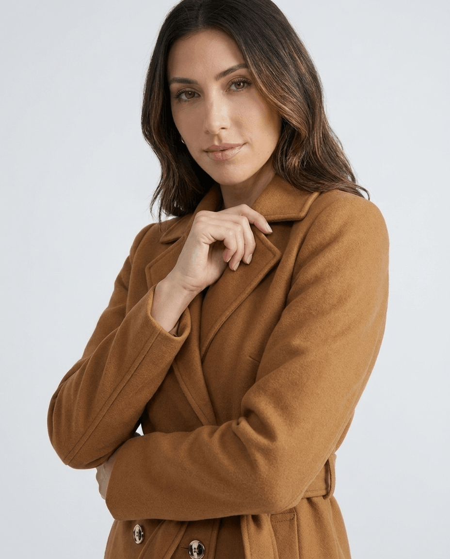 Close-up of a woman wearing a brown belted wool trench coat, showing the lapel collar and tailored fit