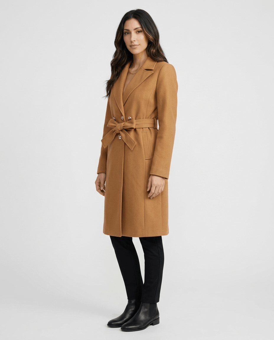 A woman wearing a brown belted wool trench coat with a tailored fit, lapel collar, and long sleeves