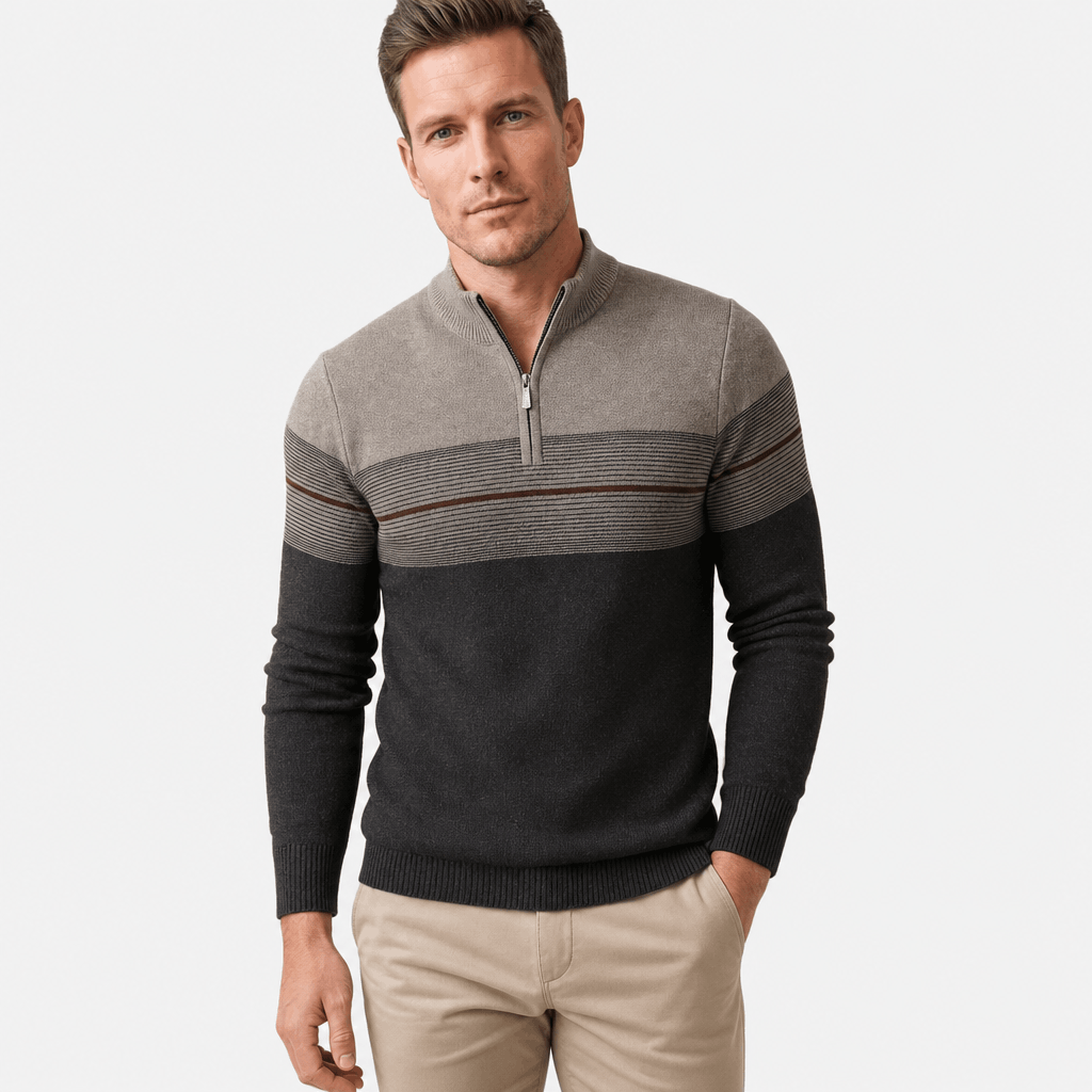 Man wearing a gray and black color-block quarter-zip sweater with beige pants.