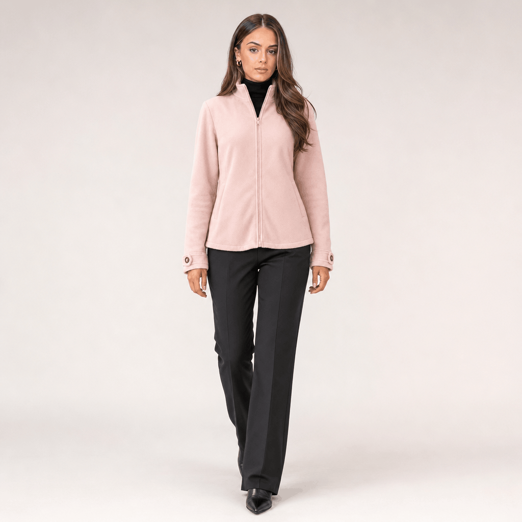 Full-body view of a female model wearing the light blush pink zip-up jacket in a relaxed standing pose.