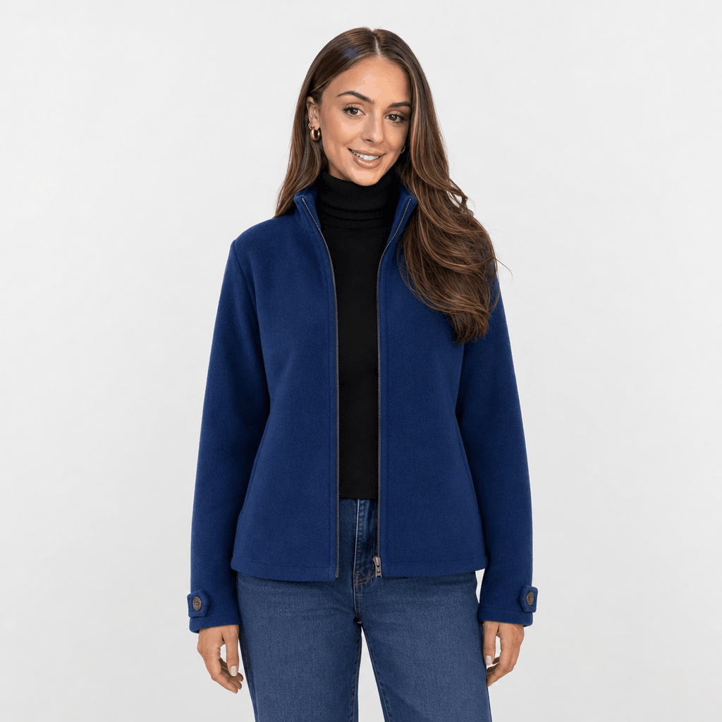Female model wearing a navy blue zip-up jacket with blue jeans.