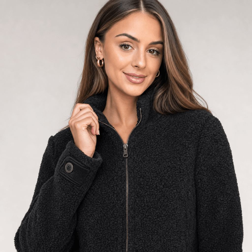 Close-up of the female model wearing the black zip-up jacket, showing the full-length zipper and fitted silhouette.