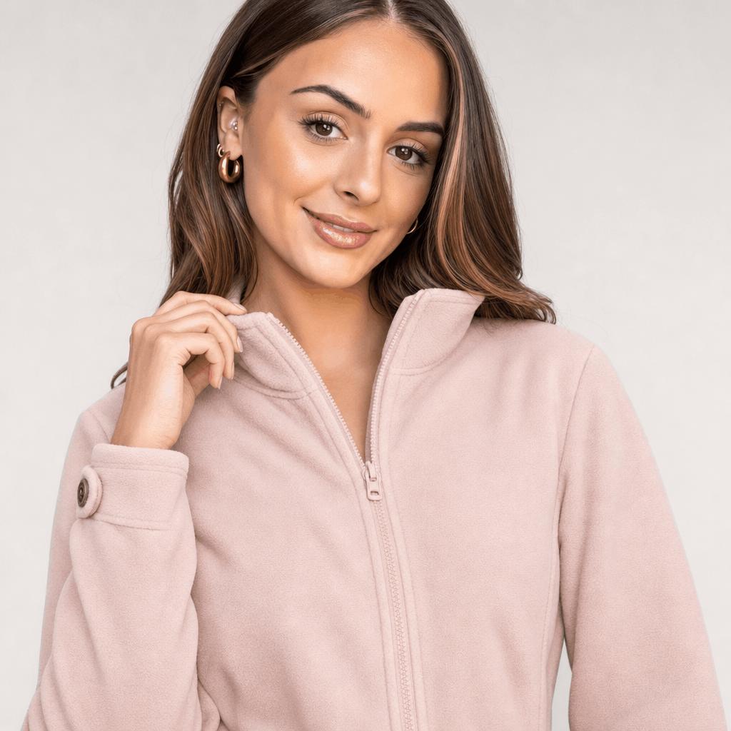 Close-up of the female model wearing the light blush pink jacket, highlighting the front zipper and stand collar.