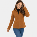 Female model wearing a camel brown zip-up jacket with a stand collar, paired with a black top and blue jeans.