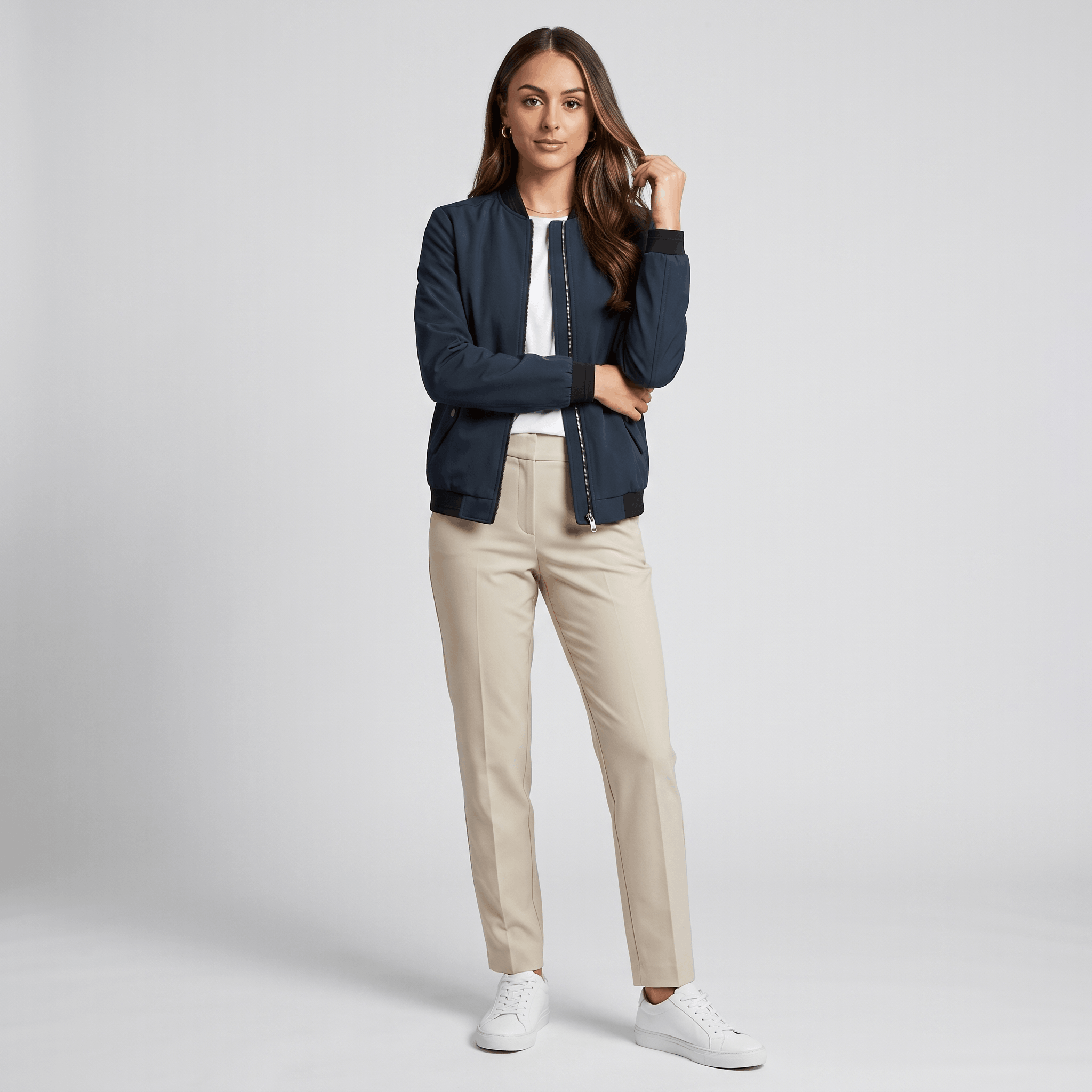 Female model wearing the navy blue bomber jacket with beige trousers and black shoes.