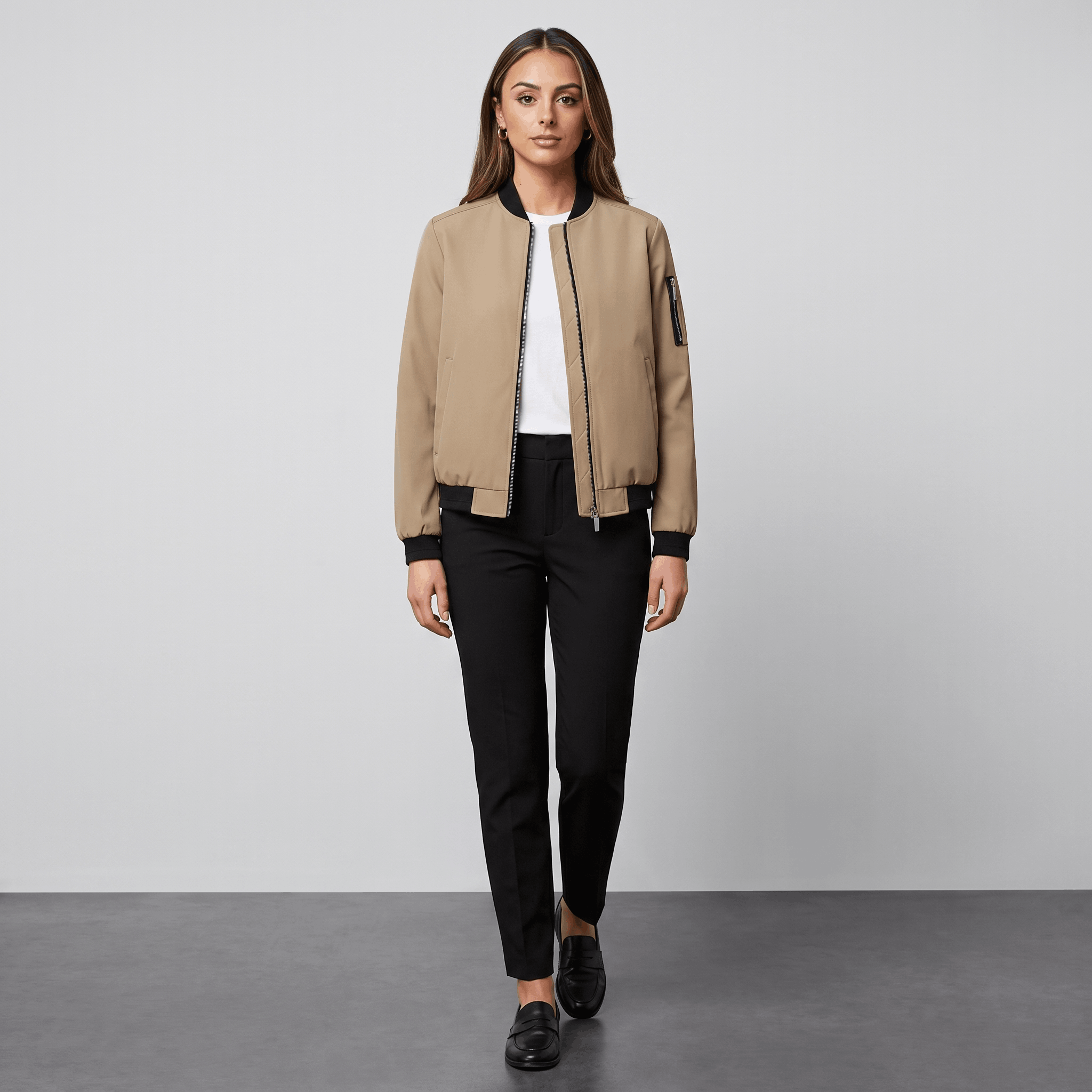 Female model wearing the beige bomber jacket with black trousers and black shoes.