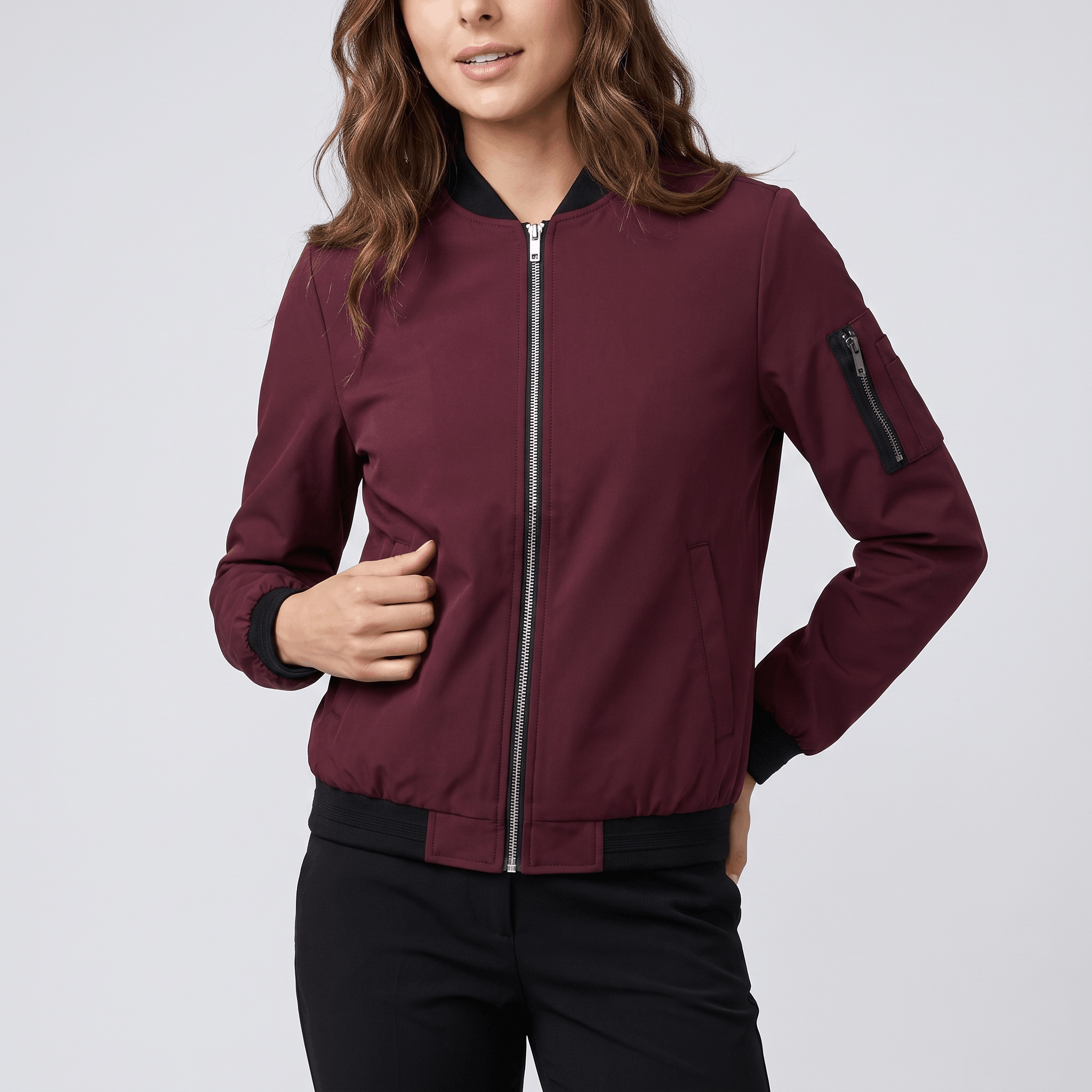 Burgundy bomber jacket with a full front zipper, ribbed collar, cuffs, and hem, plus a zippered sleeve pocket.