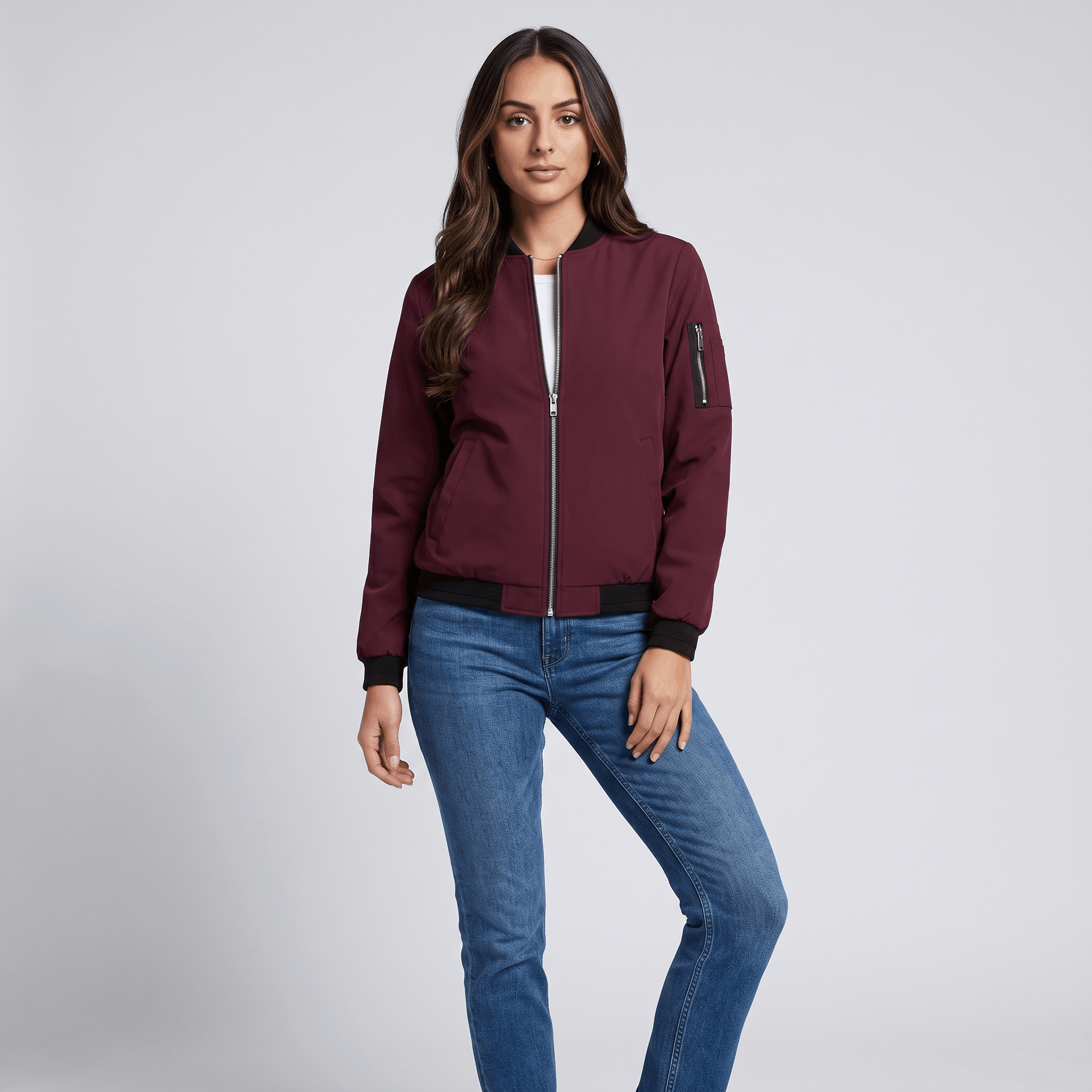 Female model wearing the burgundy bomber jacket with blue jeans.