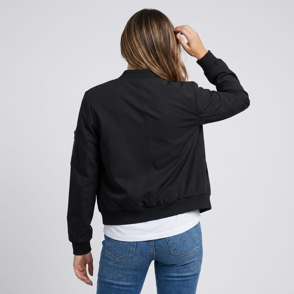 Female model wearing the black bomber jacket, showing the back and ribbed waistband.
