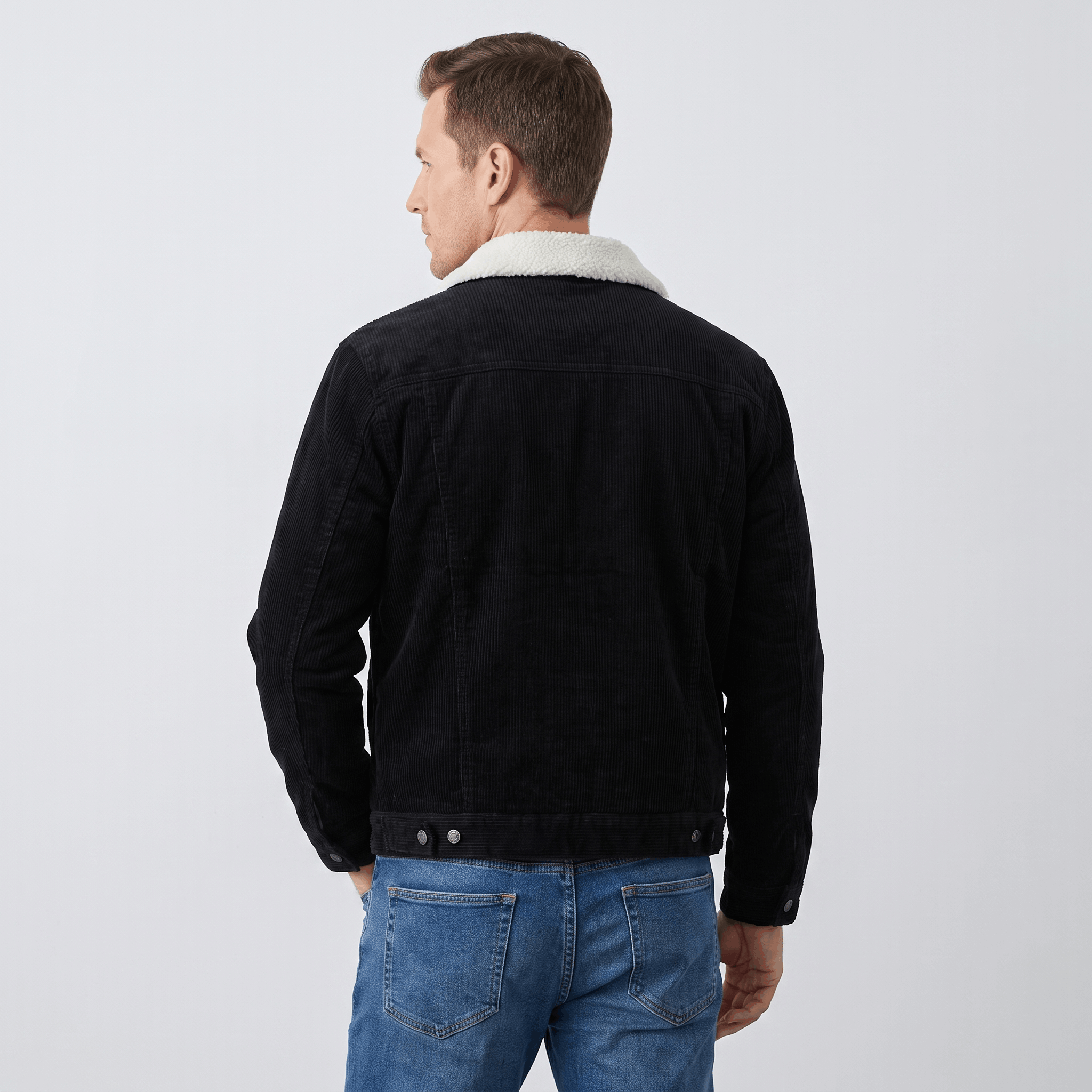 Black corduroy trucker jacket with a white sherpa collar worn from the back.