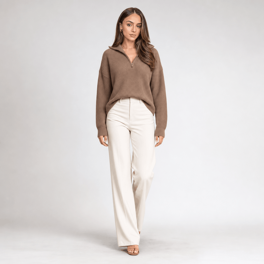 Full-body view of the woman wearing the taupe brown ribbed half-zip sweater with white wide-leg pants.