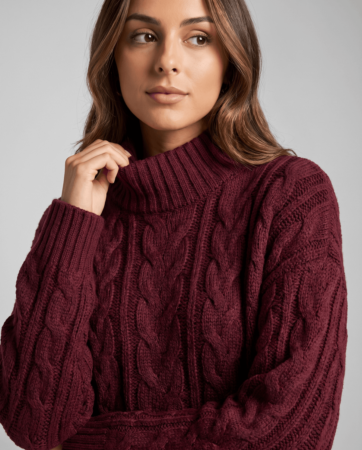 Burgundy Cable Knit Sweater worn by a female model, shown in close-up to highlight the cable knit texture, oversized fit, and high neckline.