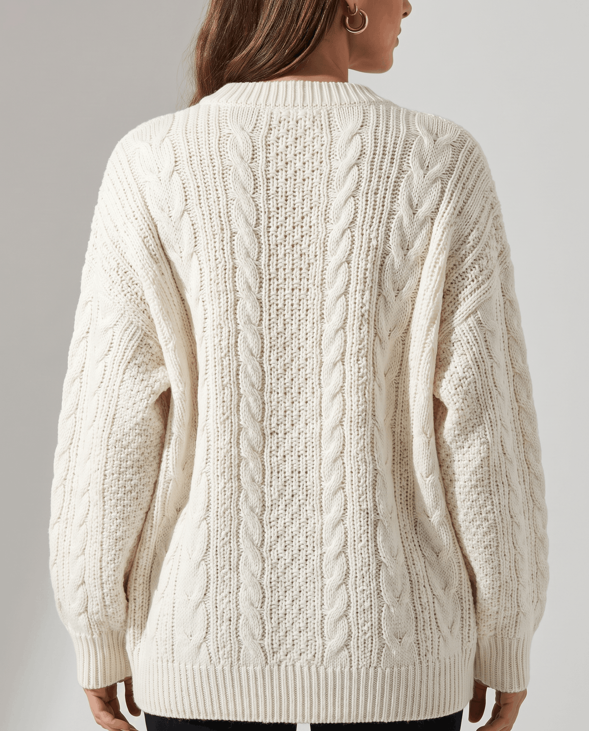 Cream Cable Knit Sweater worn by a female model from the back, highlighting the textured cable knit pattern, oversized silhouette, and balloon sleeves.