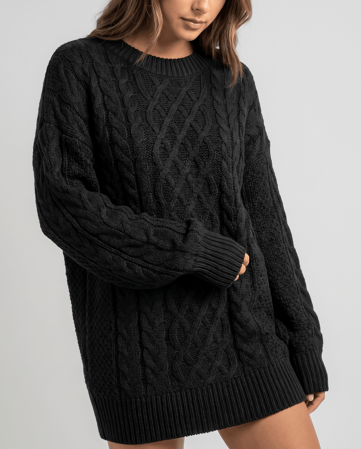 Black Cable Knit Sweater worn by a female model, featuring an oversized fit, textured cable knit pattern, long balloon sleeves, and relaxed silhouette.