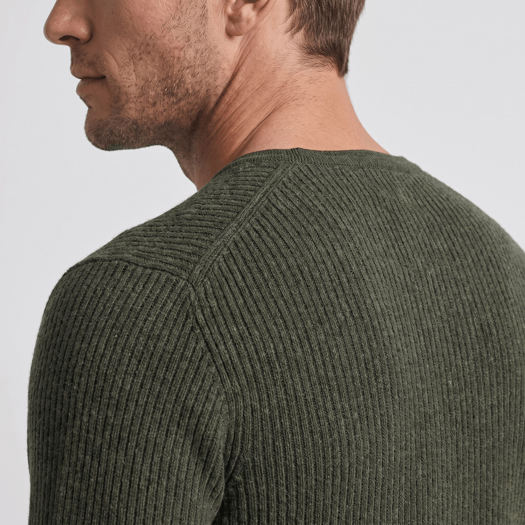 Olive green ribbed knit henley sweater with a structured regular fit worn by a man.