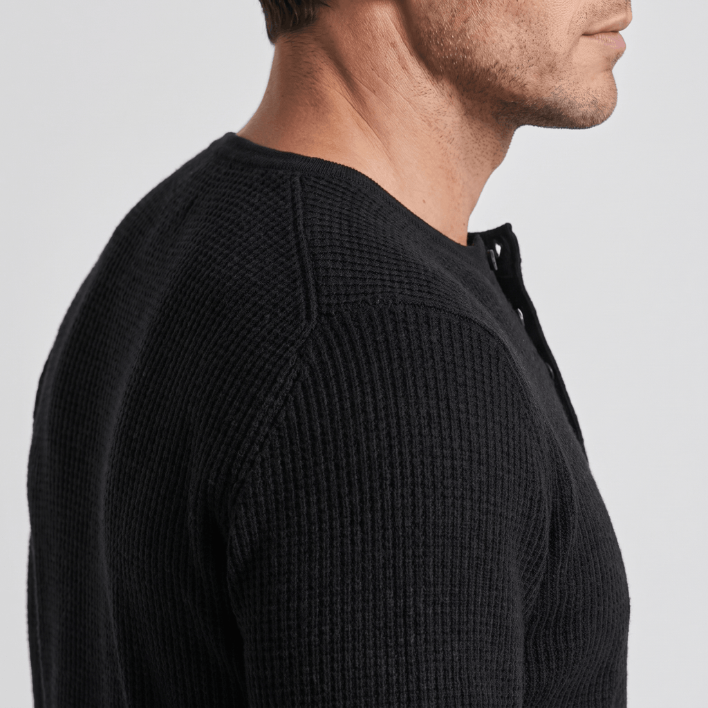 Black ribbed knit henley sweater featuring a four-button placket and a structured regular fit.