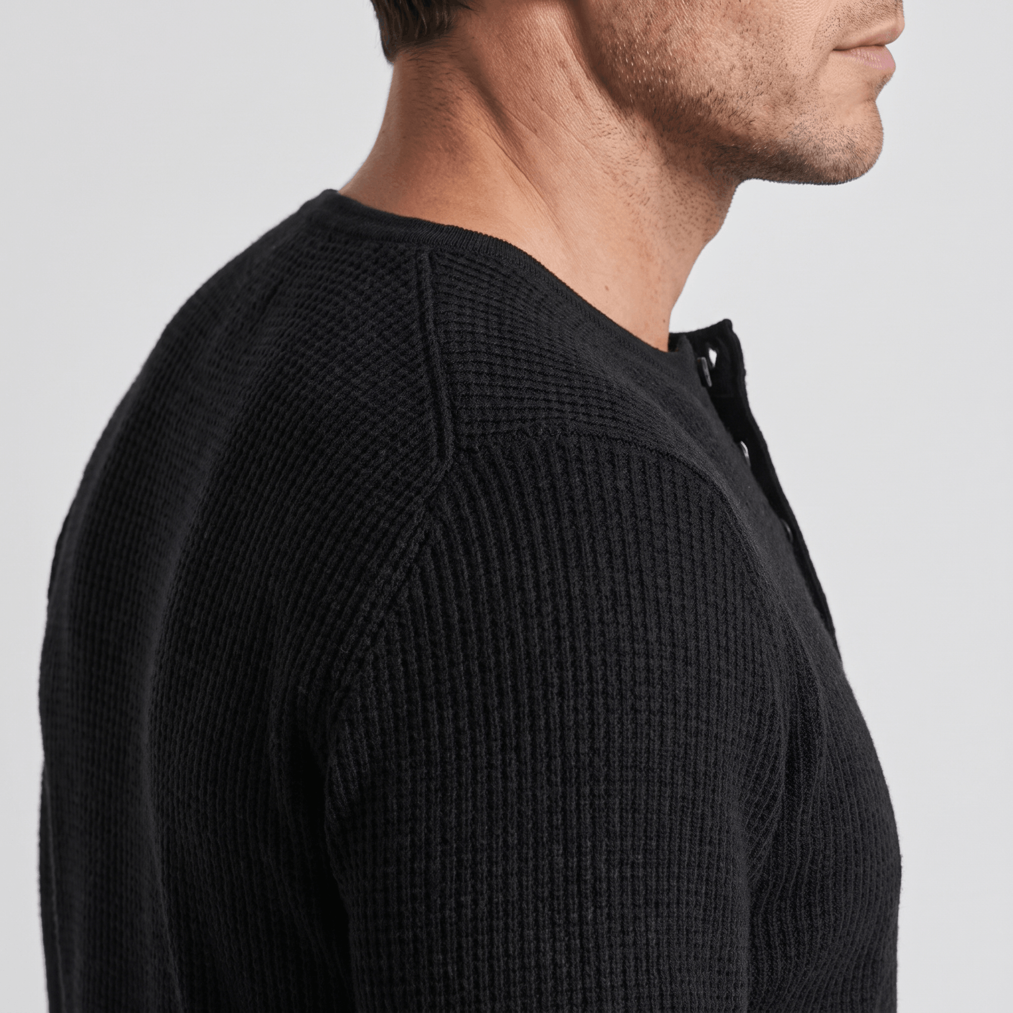 Black ribbed knit henley sweater featuring a four-button placket and a structured regular fit.
