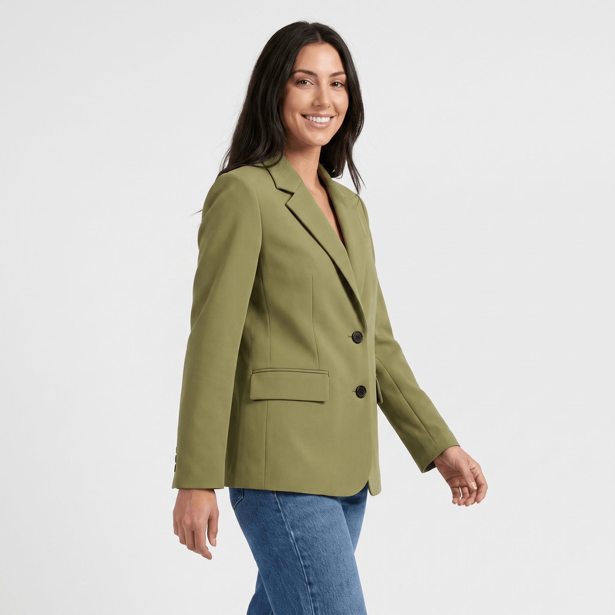 Female model wearing an olive green tailored blazer with notched lapels, a single-button closure, and flap pockets, paired with dark trousers.