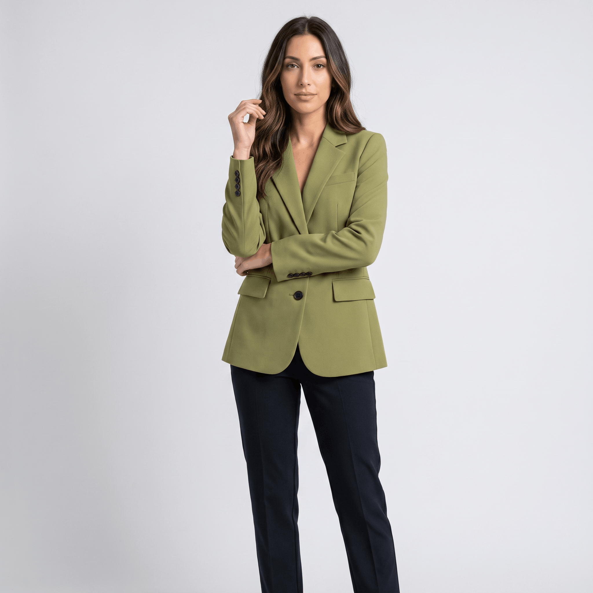 Female model wearing the olive green blazer over a light-colored top with dark trousers.