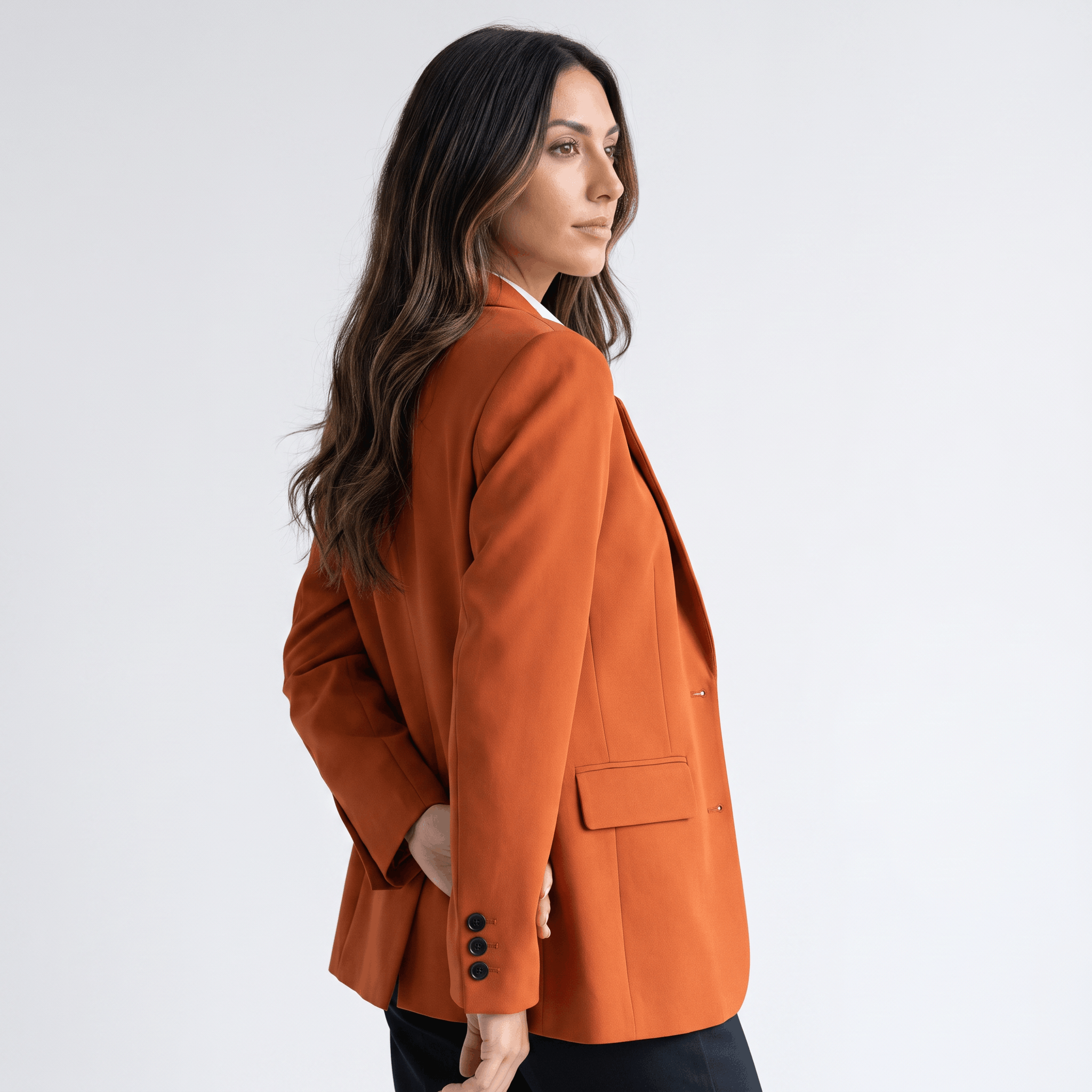 Female model wearing the burnt orange blazer, showing the fitted back and long sleeves.