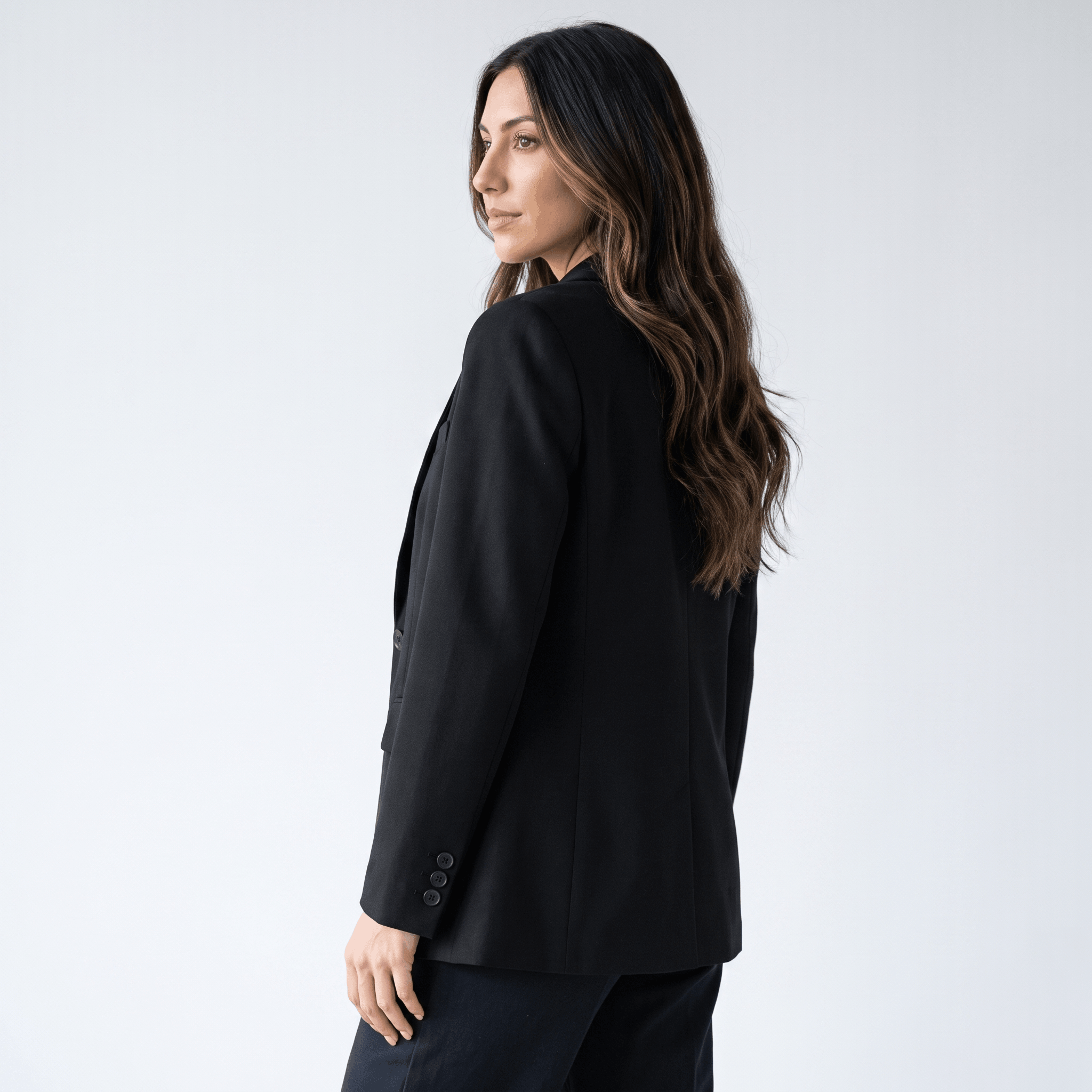 Female model wearing the black blazer, showing the fitted back and long sleeves.