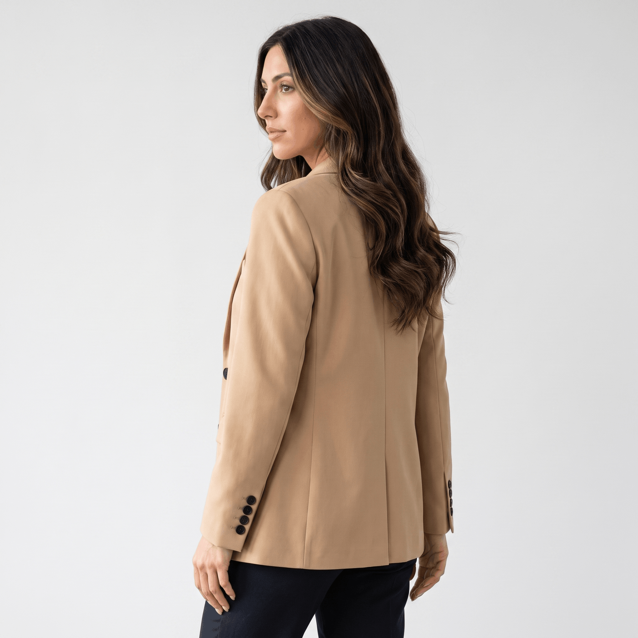 Female model wearing the beige blazer, highlighting the fitted back and long sleeves.