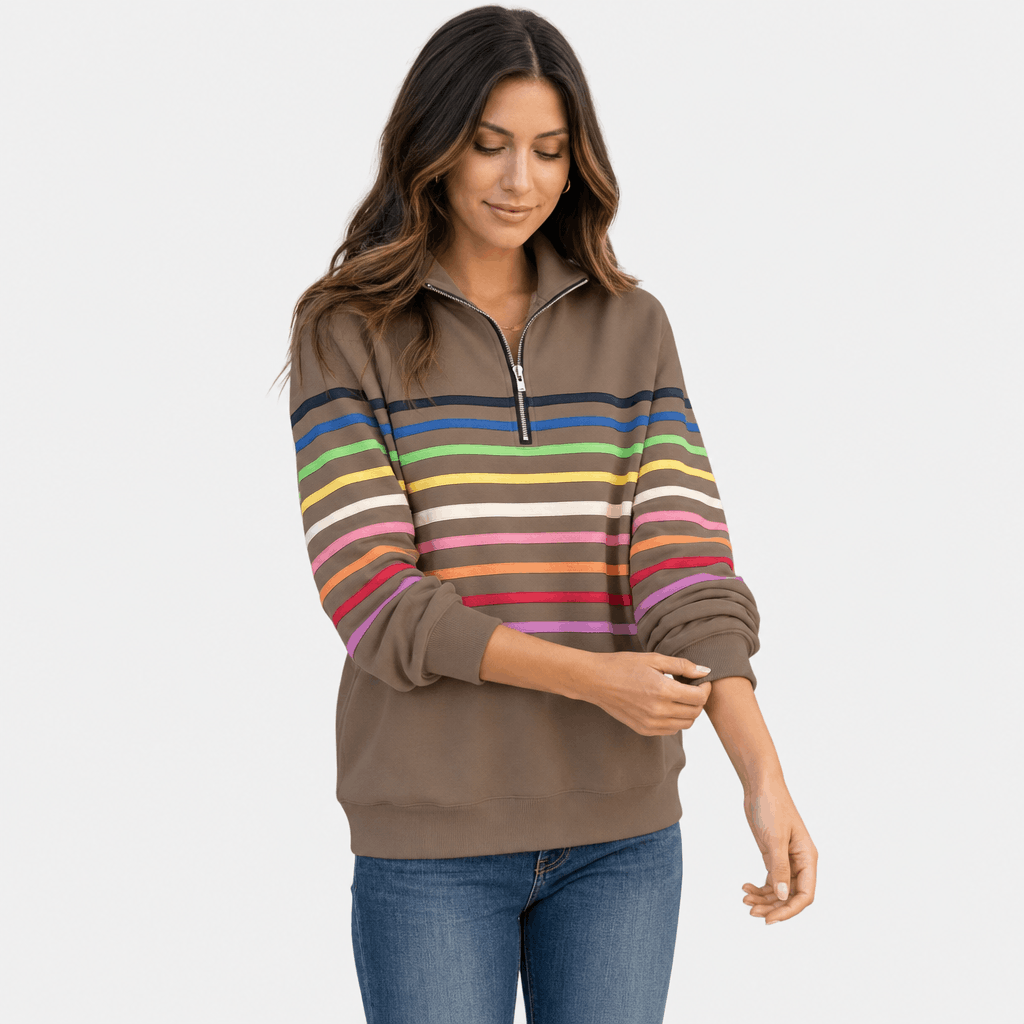 Female model wearing a taupe quarter-zip sweater with multicolored horizontal stripes, shown in a relaxed front-facing pose.