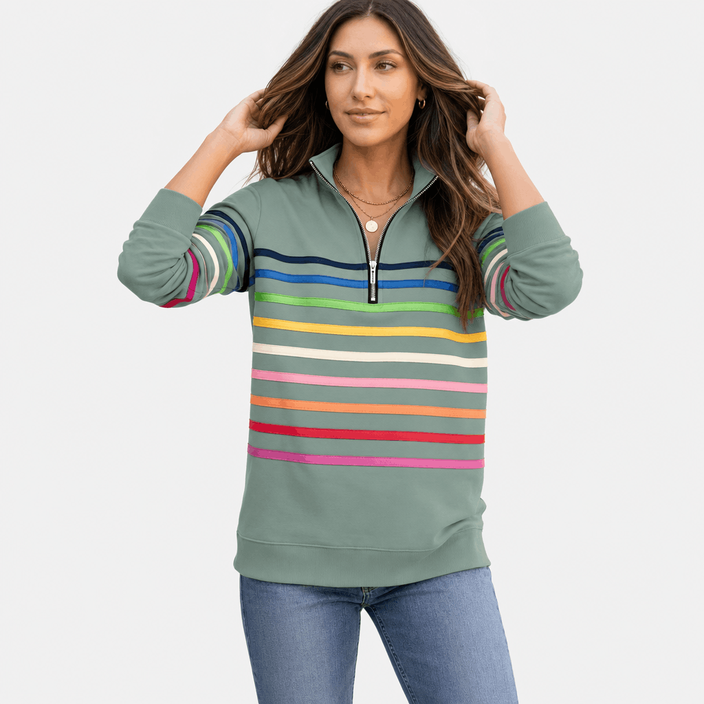 Female model wearing a sage green quarter-zip sweater with multicolored horizontal stripes, adjusting the collar.