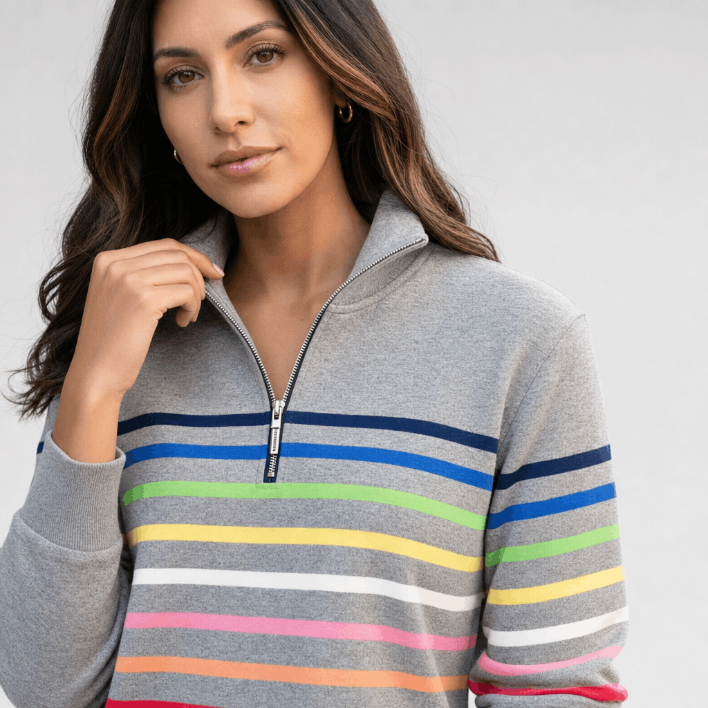 Close-up of the female model wearing the gray multicolored striped quarter-zip sweater, highlighting the zipper collar and colorful stripe pattern.