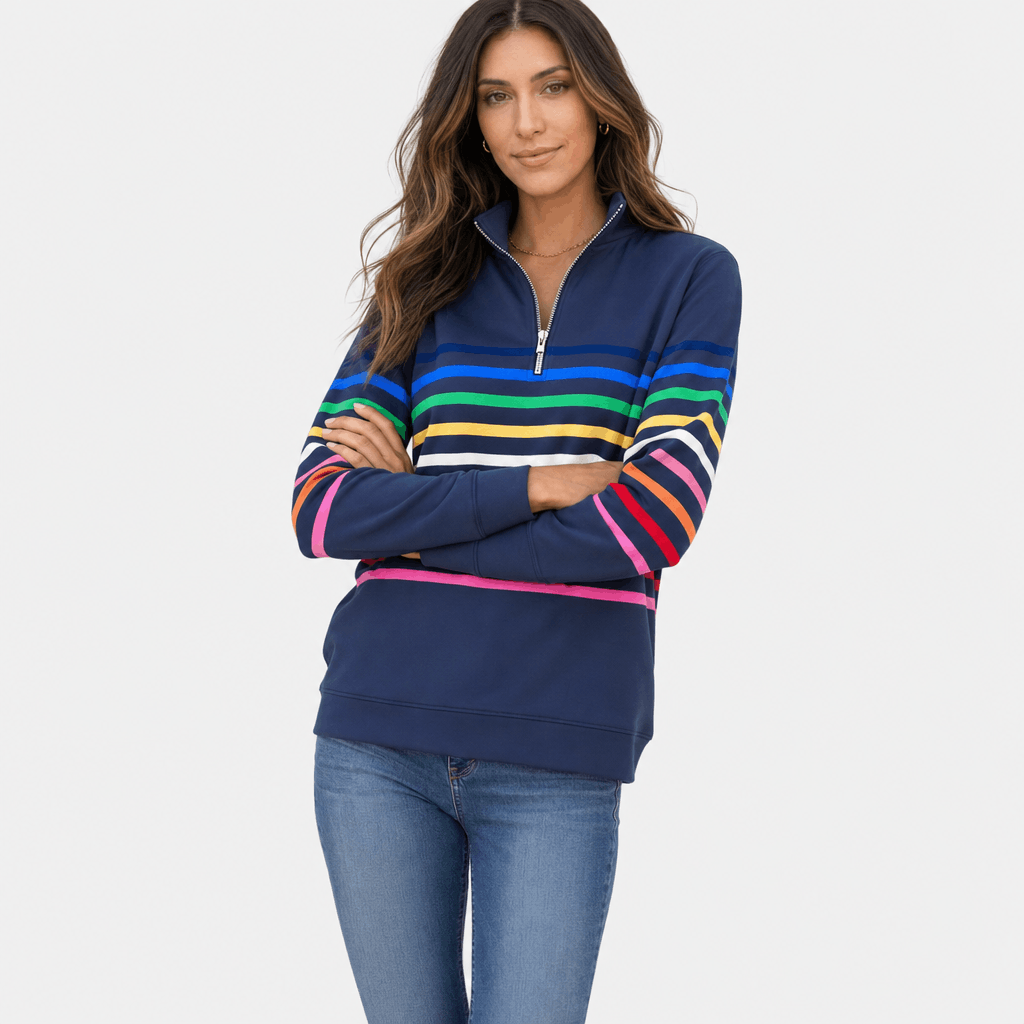 Female model wearing a navy quarter-zip sweater with multicolored horizontal stripes, arms crossed, paired with blue jeans.