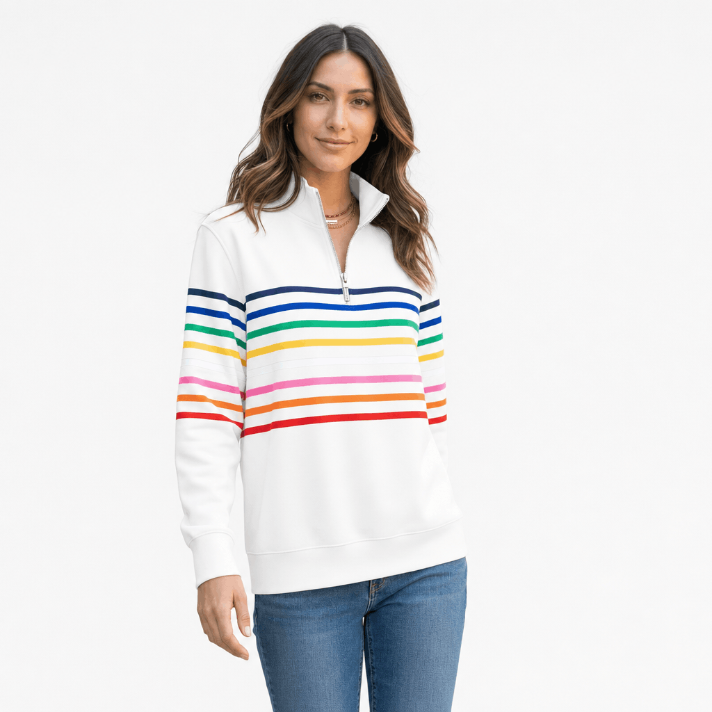 Female model wearing a white quarter-zip sweater with multicolored horizontal stripes, paired with blue jeans.