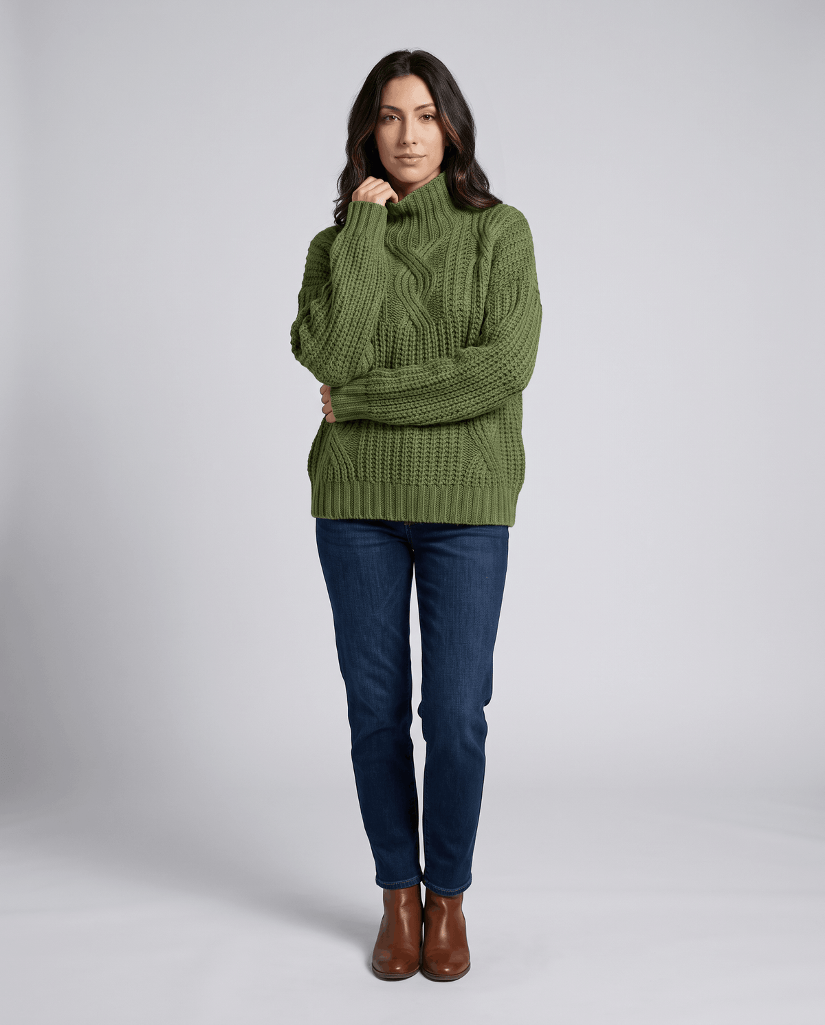 Green Chunky Cable Knit Sweater worn by a female model with blue jeans, featuring a mock neck, relaxed fit, chunky cable knit texture, and long sleeves.